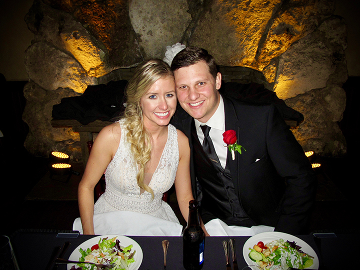 The wedding couple at their sweetheart table in frotn of the vintage fireplace at Dubsdread.