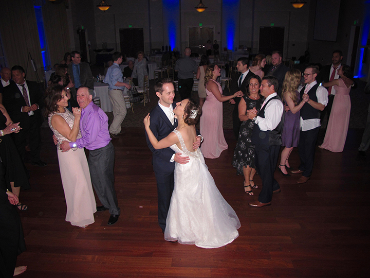 The Wedding Couple dance together with their guests at the reception in Lake Mary.
