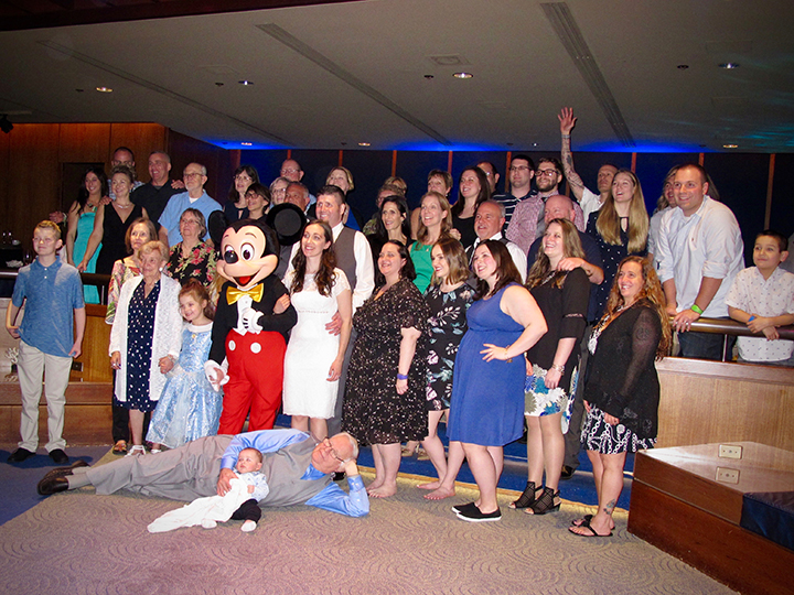 Mickey Mouse joins wedding guests a reception for a group shot of family and friends.