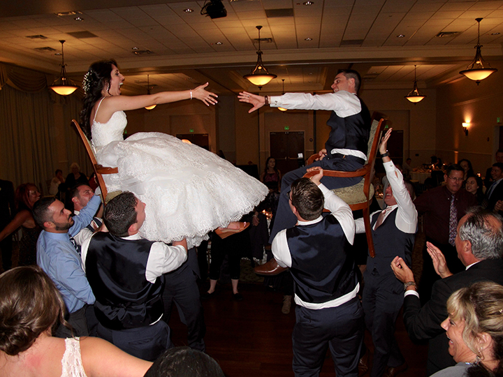 The Bride and Groom are lifted high into the air on chairs during the Hora Dance.