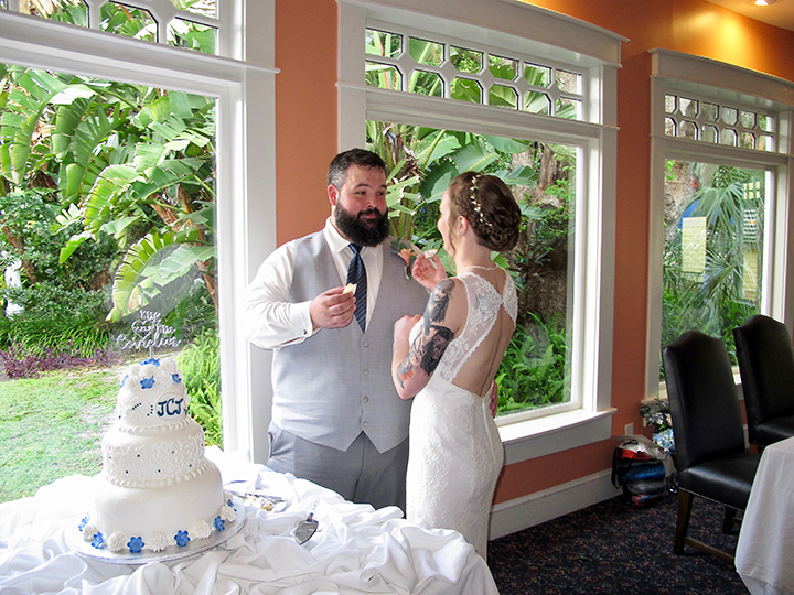 The wedding couple cut the cake and are about to feed each other at the Lakeside Inn in Mt Dora.