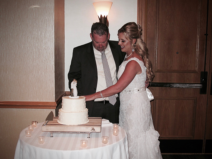 The Bride and Groom cut the cake at their wedding reception.