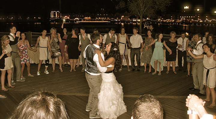 A bride and groom share their last dance surrounded by family and friends at their wedding.