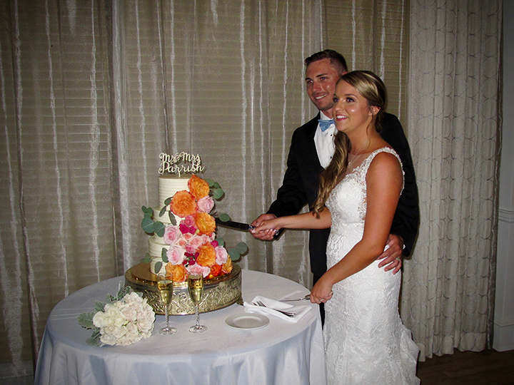 The bride and groom cut their cake at their wedding reception in Lake Nona, FL.