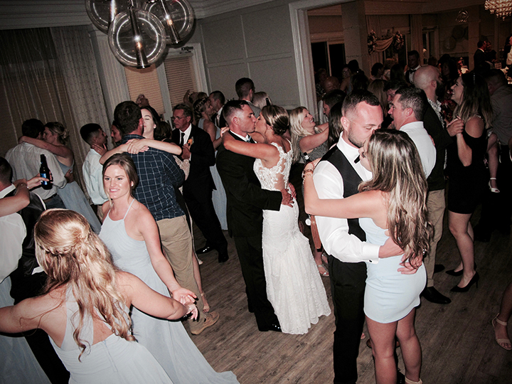 the wedding couple share the dance floor with friends and family during their reception.