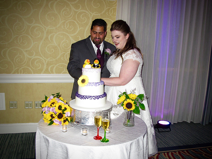 Orlando DJ Chuck Johnson helps this couple cut the wedding wedding cake at their reception.