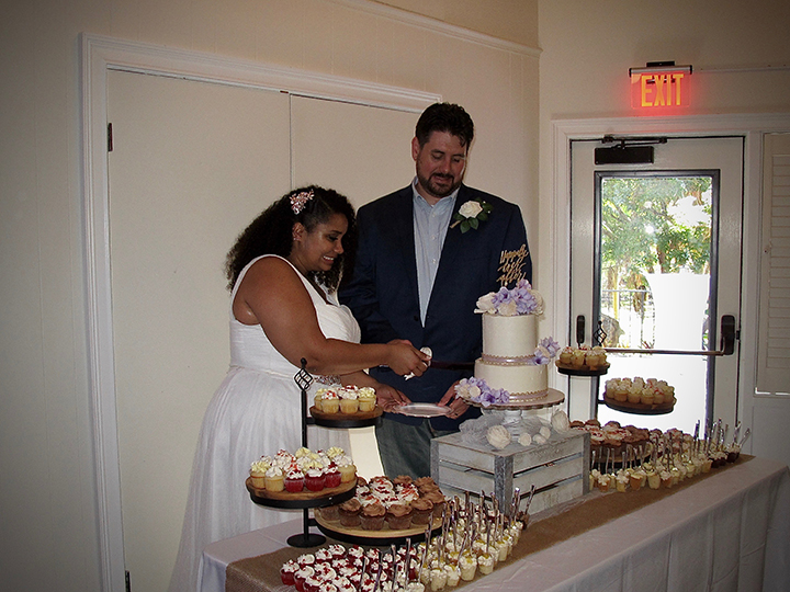 Orlando DJ Chuck Johnson help the wedding couple cut their cake at their reception.
