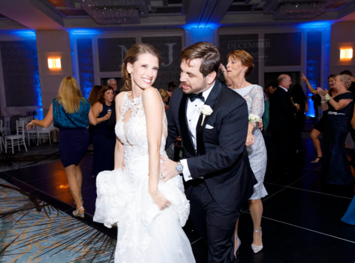 a bride and groom having fun on the dance floor at the four seasons resort wedding venue in orlando florida