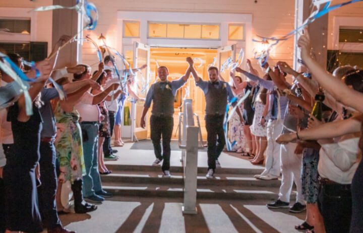 two grooms celebrate their grand exit from their same-sex wedding reception