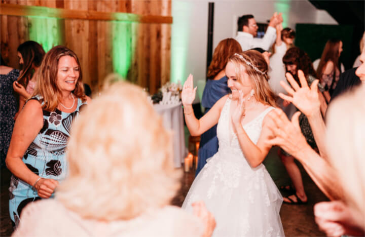 a bride dances with her friends at the moss estates wedding venue